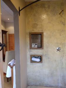 a bathroom with a towel rack on a wall at VULTURES LODGE in Zastron