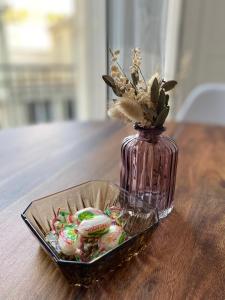 Un jarrón de cristal con galletas en un bol sobre una mesa. en Appartement luxueux rénové avec balcon & garage, en Troyes