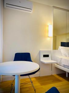 um quarto com uma mesa branca e cadeiras azuis e uma cama em Lika's Apartment em Batumi