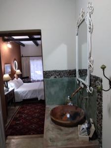 ein Bad mit einem Waschbecken in einem Hotelzimmer in der Unterkunft VULTURES LODGE in Zastron
