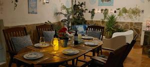 una mesa de madera con platos y botellas de vino. en El Buen Ocio Holiday Rental, en Castellón de Rugat