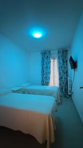 a room with two beds and a blue light at Residenza Martellotta in Bari