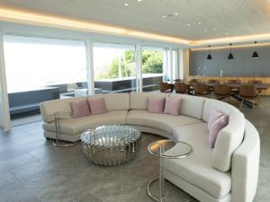 ein Wohnzimmer mit einem weißen Sofa und rosa Kissen in der Unterkunft CORAL SUITE VILLA awaji in Awaji