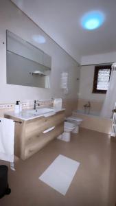 bagno con 2 servizi igienici, lavandino e specchio di Residenza Martellotta a Bari