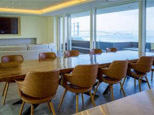 ein Konferenzraum mit einem großen Holztisch und Stühlen in der Unterkunft CORAL SUITE VILLA awaji in Awaji