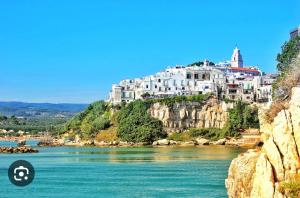 a town on top of a mountain next to a river at B&B Tra le vie del borgo in Vieste