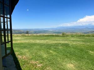 una vista desde una ventana de un campo de hierba en Windmill Farm en Bergville