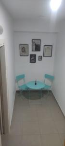 Una mesa y dos sillas en una habitación blanca en RICASOLI HOUSE, en Bisceglie