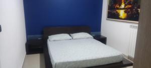 a bed in a room with a blue wall at RICASOLI HOUSE in Bisceglie