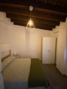 a bedroom with a bed and a light and a cabinet at Apartamento Peonía in Jerez de la Frontera