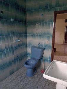 y baño con aseo azul y lavamanos. en Finca girasoles en Ayala