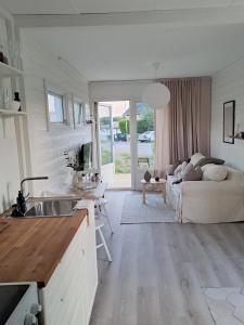 a kitchen and living room with a couch and a table at Attefallshuset in Hyllinge