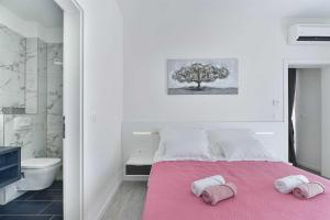 a bedroom with a pink bed with two towels on it at Luxury Stone Villa BANOVI with heated pool in Vinjerac +43 photos