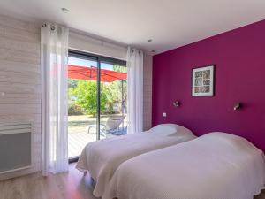 2 łóżka w sypialni z fioletową ścianą w obiekcie Villa familiale 10 pers. à Biscarrosse avec piscine chauffée, près du lac et des pistes cyclables - FR-1-319-488 w mieście Biscarrosse +21 zdjęć