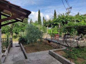 a garden with a gate and trees in the background at Apartman Amadeus in Gradina