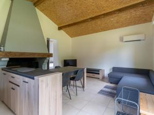 una cucina con un tavolo e un divano blu di Maison de 40m² à Biscarrosse - Proche lac, pistes cyclables, plage - Accueille 4 pers. - Animaux OK - FR-1-319-484 a Biscarrosse