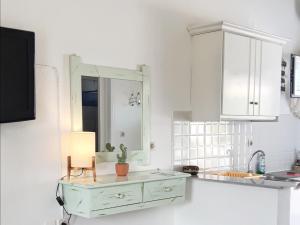 a white kitchen with a green cabinet and a cactus at Voula Accommodation in Agios Georgios +47 photos