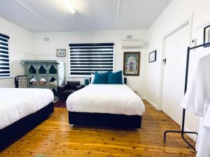 a bedroom with two beds and a chair at Town Cottage in Tenterfield