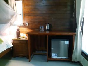 a wooden desk with a television and a night stand at The Valley Green Cottage in Nusa Penida
