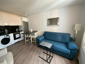 - un salon avec un canapé bleu et une table dans l'établissement Deluxe City Centre Two Bedroom with Private Balcony - Grand Central House, à Gibraltar