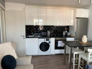 a kitchen with white cabinets and a table at Deluxe City Centre Two Bedroom with Private Balcony - Grand Central House in Gibraltar
