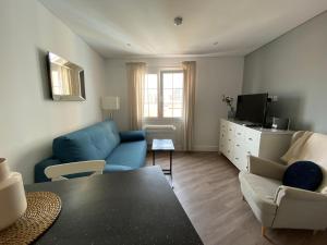 sala de estar con sofá azul y TV en Deluxe City Centre Two Bedroom with Private Balcony - Grand Central House en Gibraltar