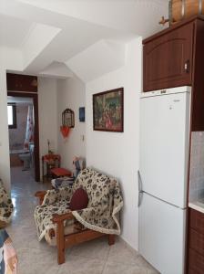 a living room with a couch and a refrigerator at Mountain Voyage Residences in Vatoússa