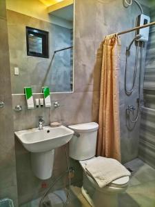 y baño con lavabo, aseo y ducha. en Dachannry's Place Hotel, en Cagayan de Oro