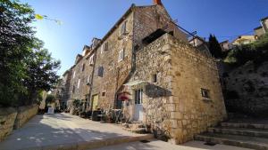 un antiguo edificio de piedra con escaleras junto a una calle en City Center Room Olivia en Hvar