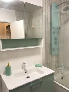 a white bathroom with a sink and a shower at Nid de rêve, vue imprenable sur Paris et terrasse 10m2 in Paris