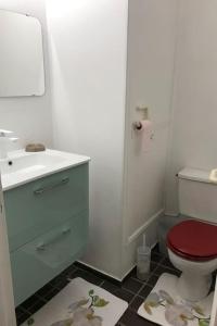 a bathroom with a red toilet and a sink at Nid de rêve, vue imprenable sur Paris et terrasse 10m2 in Paris