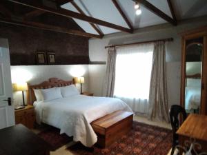 een slaapkamer met een groot bed en een raam bij VULTURES LODGE in Zastron
