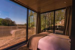 a bedroom with a bed and a large window at The Valley x Wilsum in Wilsum