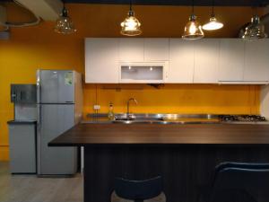 eine Küche mit weißen Schränken und einem Kühlschrank aus Edelstahl in der Unterkunft 星空間 Star co-living space in Taipeh