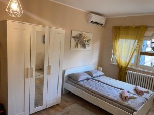 ein kleines Schlafzimmer mit einem Bett und einem Fenster in der Unterkunft Apartman Talija in Novi Sad