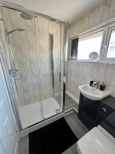 een badkamer met een douche en een wastafel bij Welsh Getaway Home No 2 - 10 mins to Bike Park Wales in Merthyr Tydfil