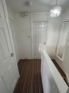 ein Zimmer mit einem Flur mit einer Tür und einem Hallwayngth in der Unterkunft Welsh Getaway Home No 2 - 10 mins to Bike Park Wales in Merthyr Tydfil
