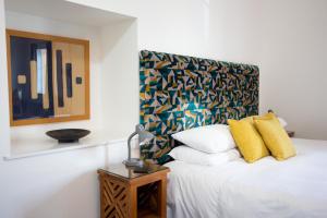 a bedroom with a white bed with a colorful headboard at Mannings Hotel in Truro +52 photos