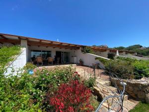 una casa con un patio con sillas y flores en Villa Erica a Valle Dell Erica, en Valle Dell’Erica