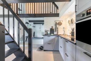 a kitchen with white cabinets and a staircase at Loft32 in Nordstrand