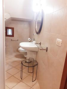 a bathroom with a sink and a toilet at Torre Marinella in Ostuni