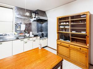 eine Küche mit weißen Schränken und einem Holztisch in der Unterkunft LOL - Vacation STAY 34627v in Hakodate