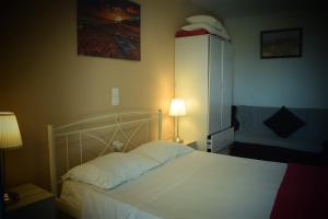 a bedroom with a white bed and a lamp at Manol Studios in Paleokastritsa