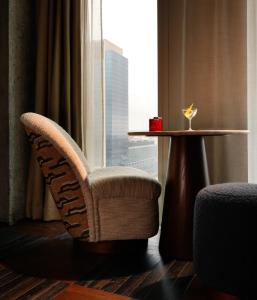 a room with a chair and a table and a window at The Hoxton, Brussels in Brussels