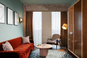 a living room with a couch and a table at The Hoxton, Brussels in Brussels