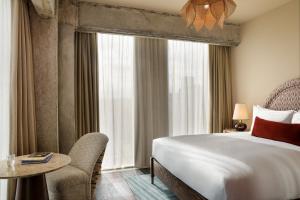 a hotel room with a bed and a table and a window at The Hoxton, Brussels in Brussels