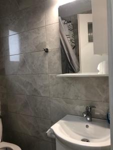 een badkamer met een wastafel en een spiegel bij Cozy studio in the Volos center in Volos
