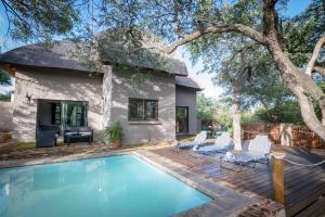 una casa con piscina delante de una casa en Nkanyi Wildlife House & Cottage, en Hoedspruit