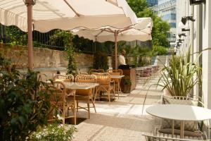 a patio with tables and chairs and an umbrella at The Hoxton, Brussels in Brussels
