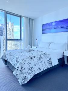 a bedroom with a large bed and a large window at LUXURY APARTMENT- with WATER VIEWS FROM EVERY DIRECTION in Gold Coast